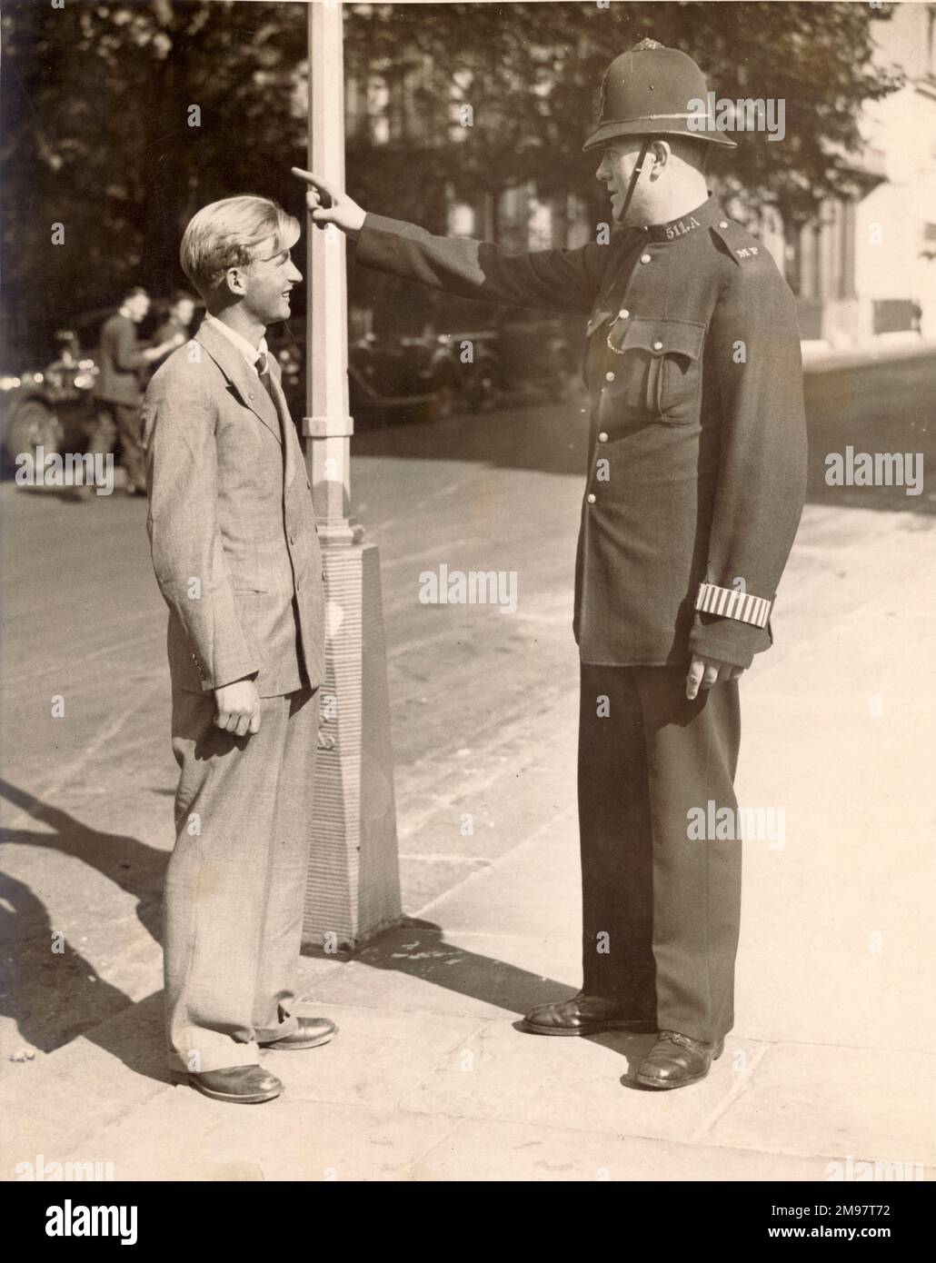C.J. ‘Jimmy’ Melrose the Australian pilot of de Havilland DH80 Puss Moth, VH-UQO, My Hildegarde, in the MacRobertson England to Australia race of October 1934. He is seen here getting directions from a London policeman after his arrival at Croydon from Darwin. Stock Photo