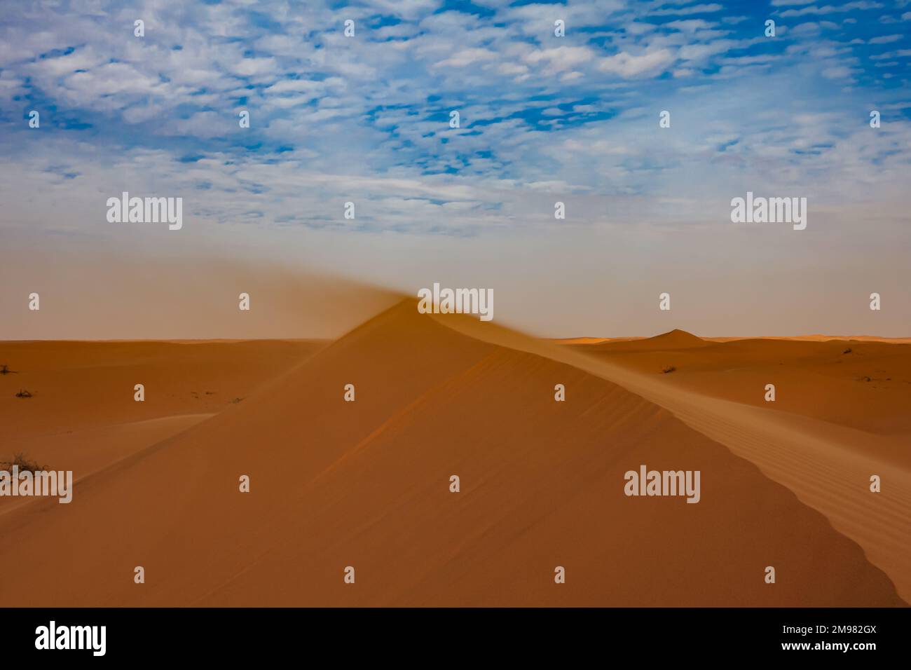 Sand blowing off the ridge of a sand dune in the desert, Saudi Arabia Stock Photo