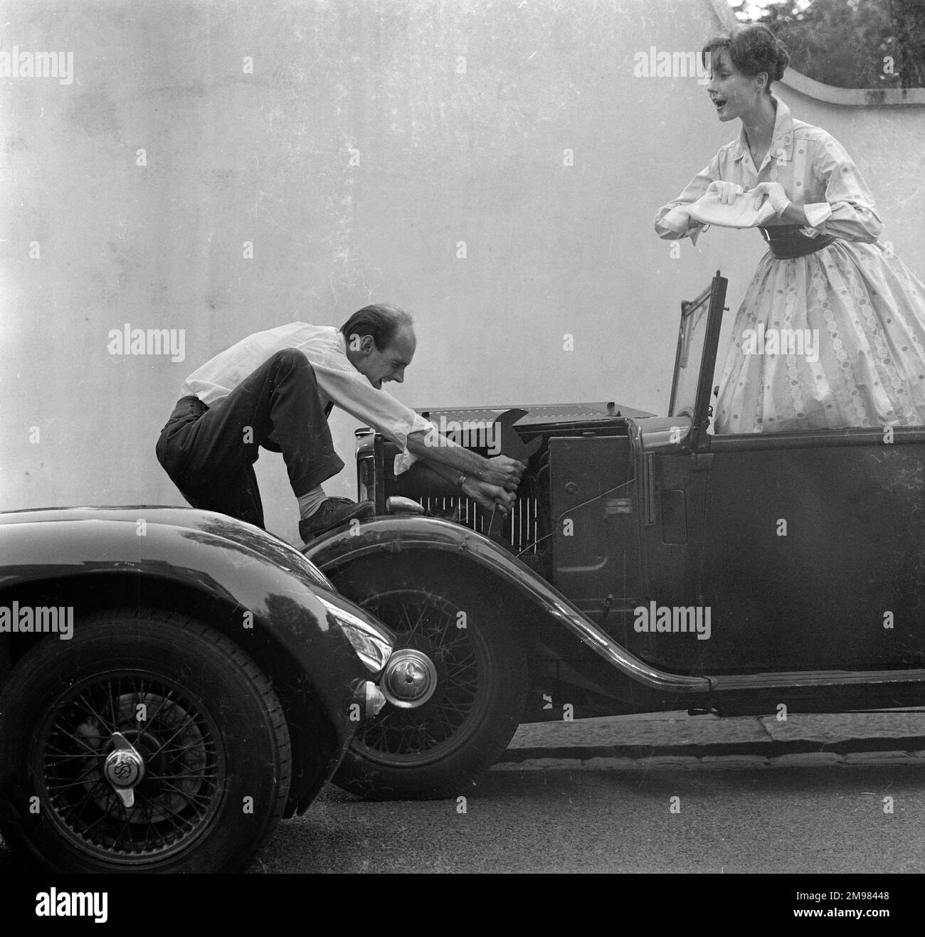 Advertisement for Manns brown ale -- male and female models posing with a car that won't start. Stock Photo