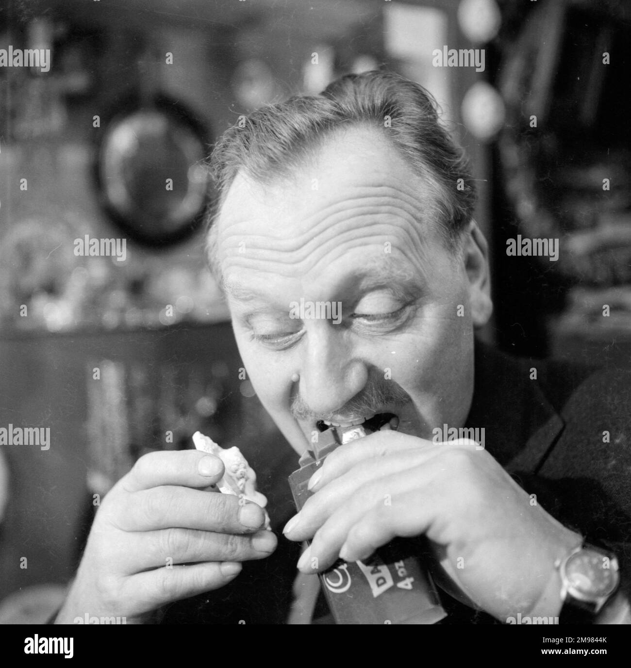 Advertisement for Cadbury's chocolate -- male model (Jack Todd) posing in an antique shop. Stock Photo