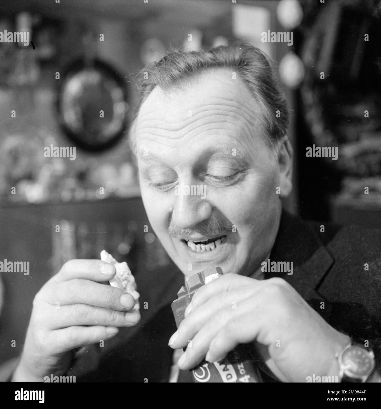 Advertisement for Cadbury's chocolate -- male model (Jack Todd) posing in an antique shop. Stock Photo