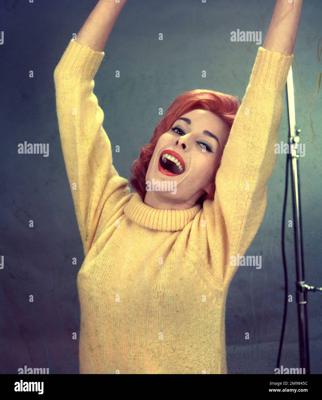 Advertisement for Pepsodent toothpaste -- female model wearing a yellow pullover with her arms raised aloft. Stock Photo