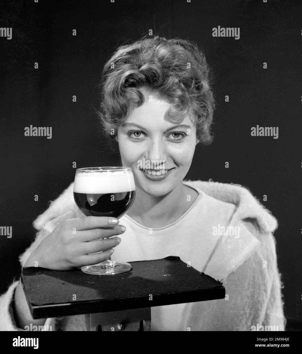 Female model (Gillian Watt) holding up a glass of beer. Stock Photo