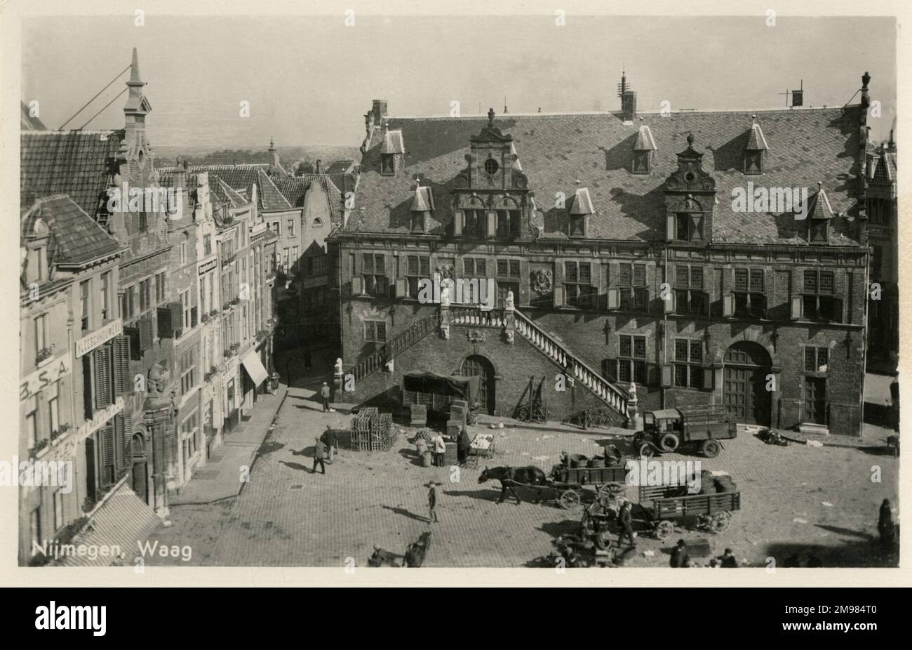 The Waag building, Grote Markt, Nijmegen The Netherlands, has been used as a meat market, the image shows horse drawn waggons in the square. Stock Photo