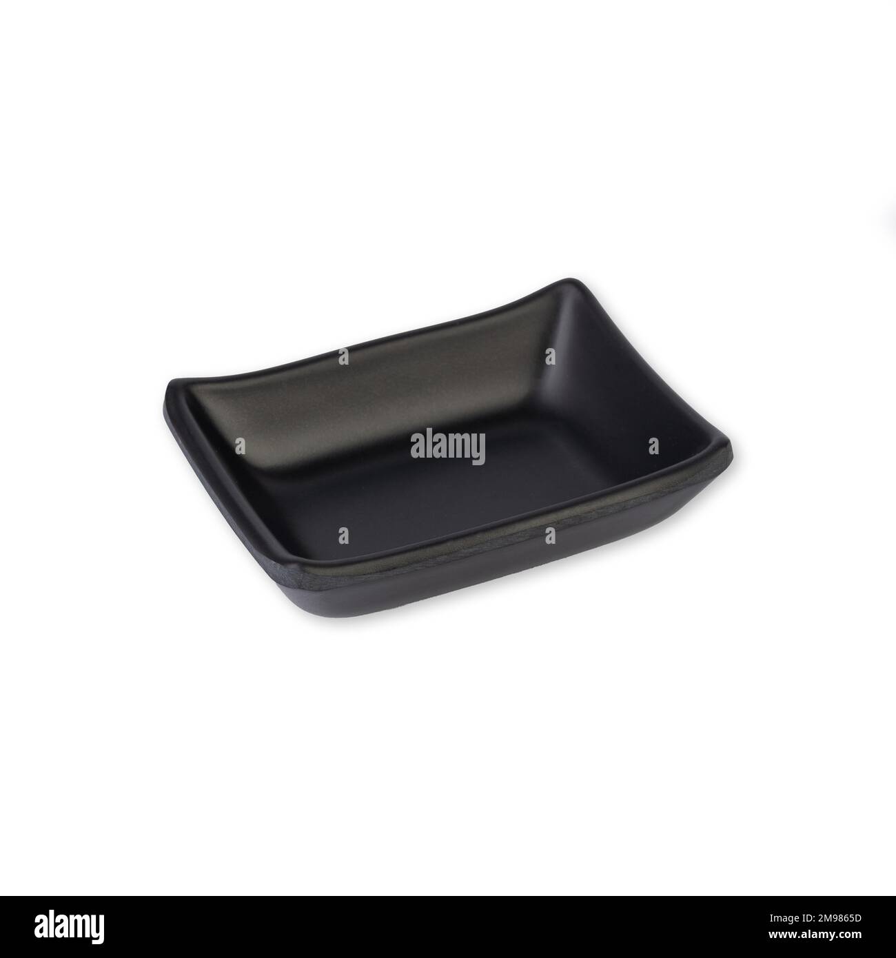 Small black ceramic plate isolated over white background. Stock Photo