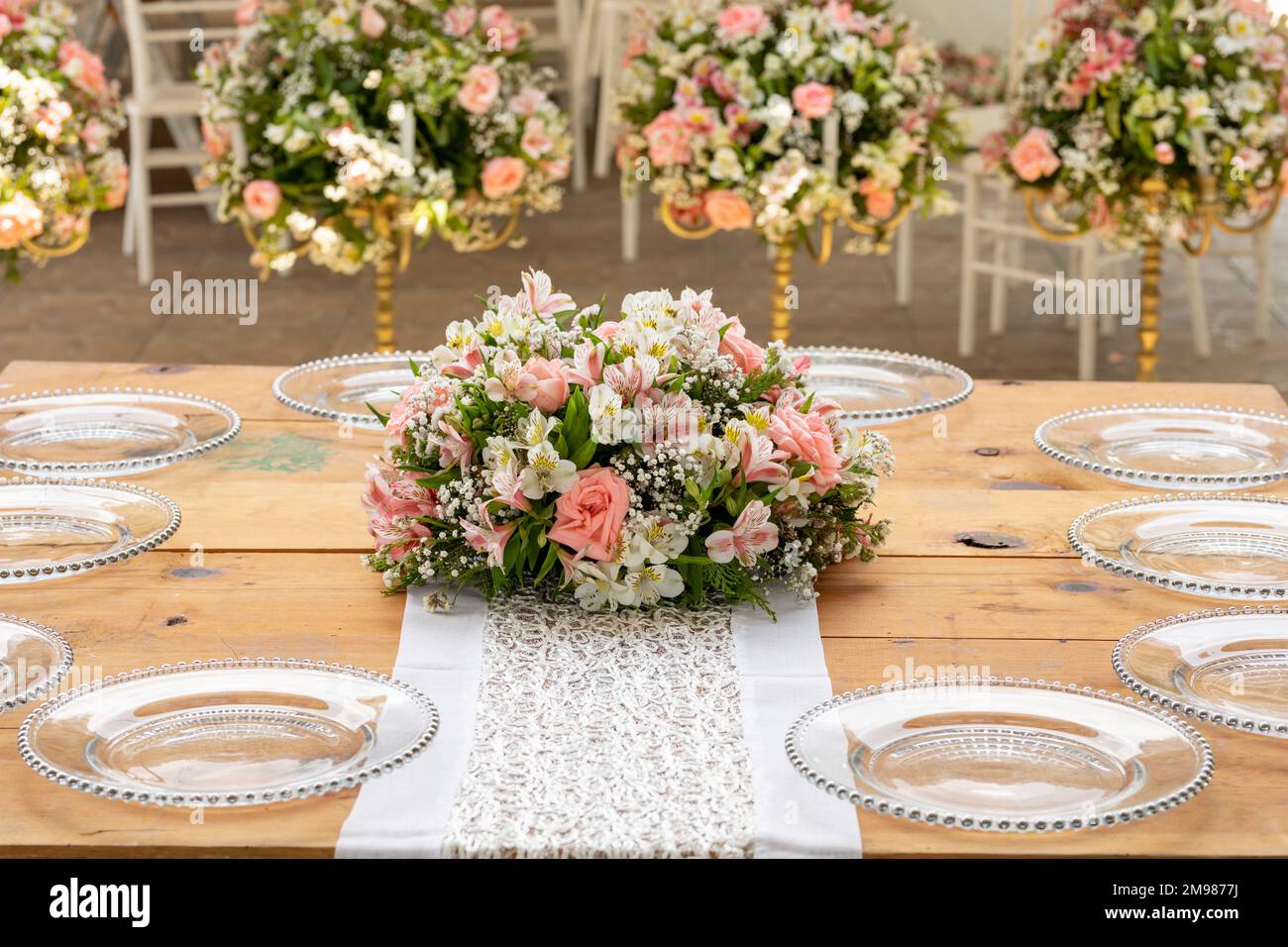 Social event table with glassware and a bouquet of flowers in the centre. Stock Photo