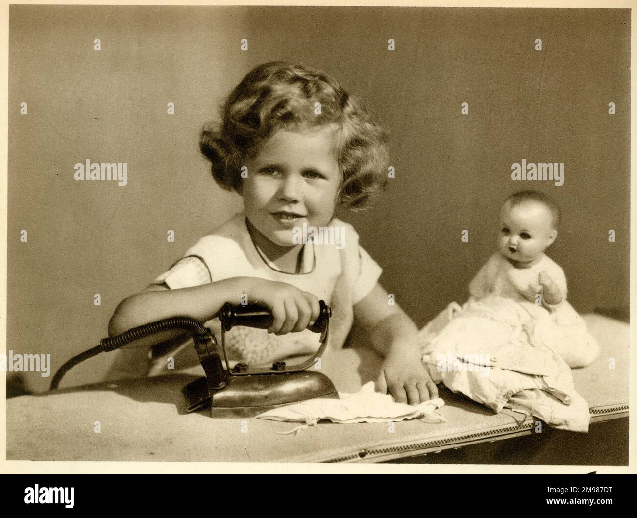 Little girl ironing her doll's clothes Stock Photo Alamy