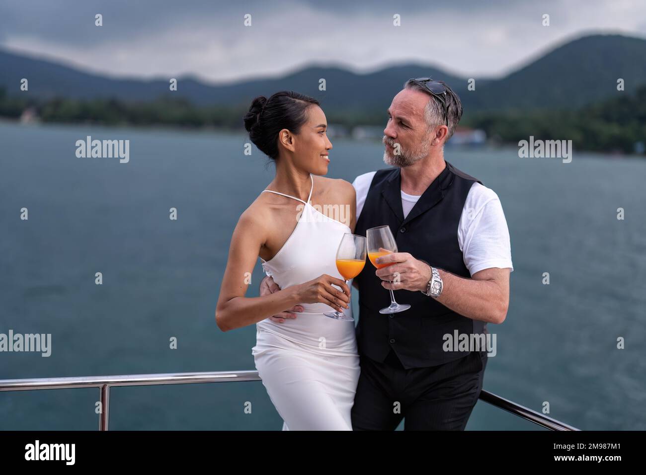 Romantic couple in love have fun sailing in the sea standing on yacht