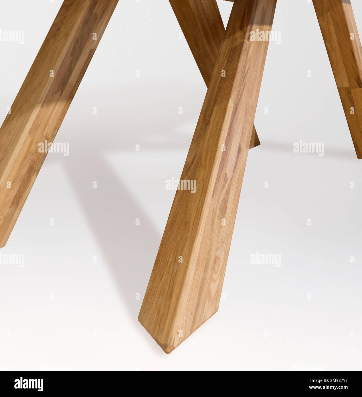 Wooden table legs isolated over white background, close view photo