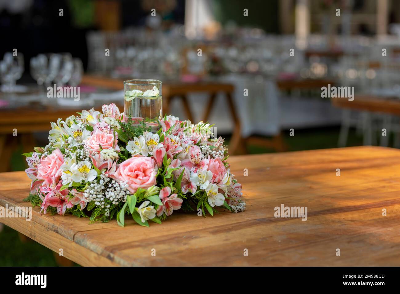 flower arrangement on a wooden table in a garden of a social event Stock Photo