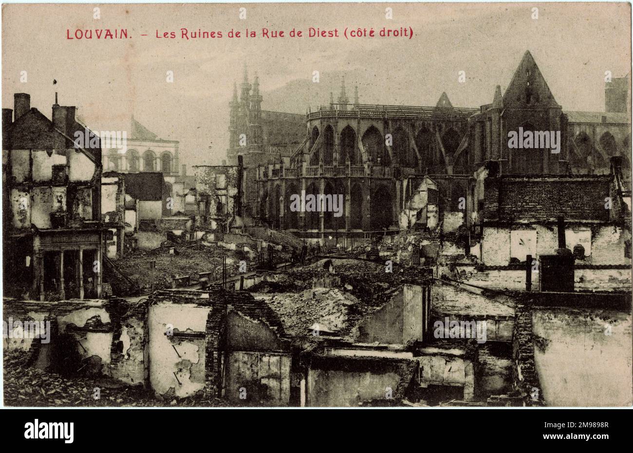Louvain (Leuven), Belgium - damage in the Rue de Diest during WW1, with St Peter's Church on the right showing some damage to the roof, and the three spires of the Town Hall visible in the middle distance. Stock Photo