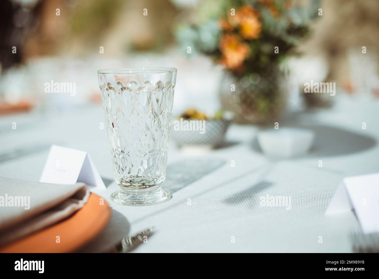 Crystal glass on a formal dining table with blank name cards Stock