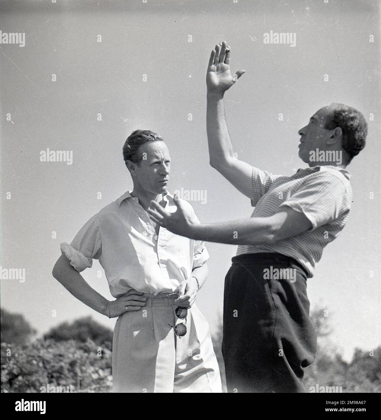 Leslie Howard (1893-1943), English actor, and Georges Perinal (1897-1965), French cinematographer, on location during the filming of The First of The Few, in which Howard played the Spitfire designer RJ Mitchell. Stock Photo