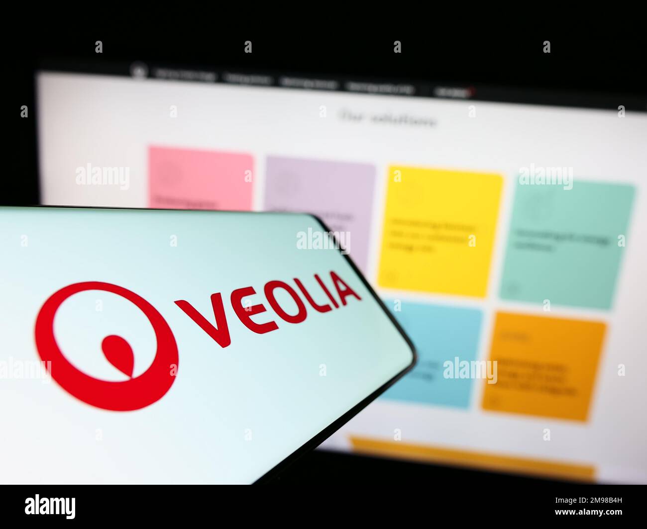 Smartphone with logo of French company Veolia Environnement SA on screen in front of business website. Focus on center-left of phone display. Stock Photo