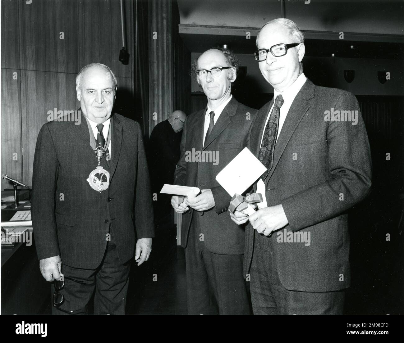Charles Abell, OBE, FSLAET, CEng, FRAeS, 1910-1998, Royal Aeronautical Society President 1976-1977, left, presents the 1977 George Taylor (of Australia) Written Paper Prize on 12 May 1977 to A.C. Ham, centre, and A.J. ?Jack? Willshire, right, for their paper ?Advanced materials and their use in civil aircraft structures?. Jack worked in the Future Projects Office of British Aerospace at Hatfield. Stock Photo