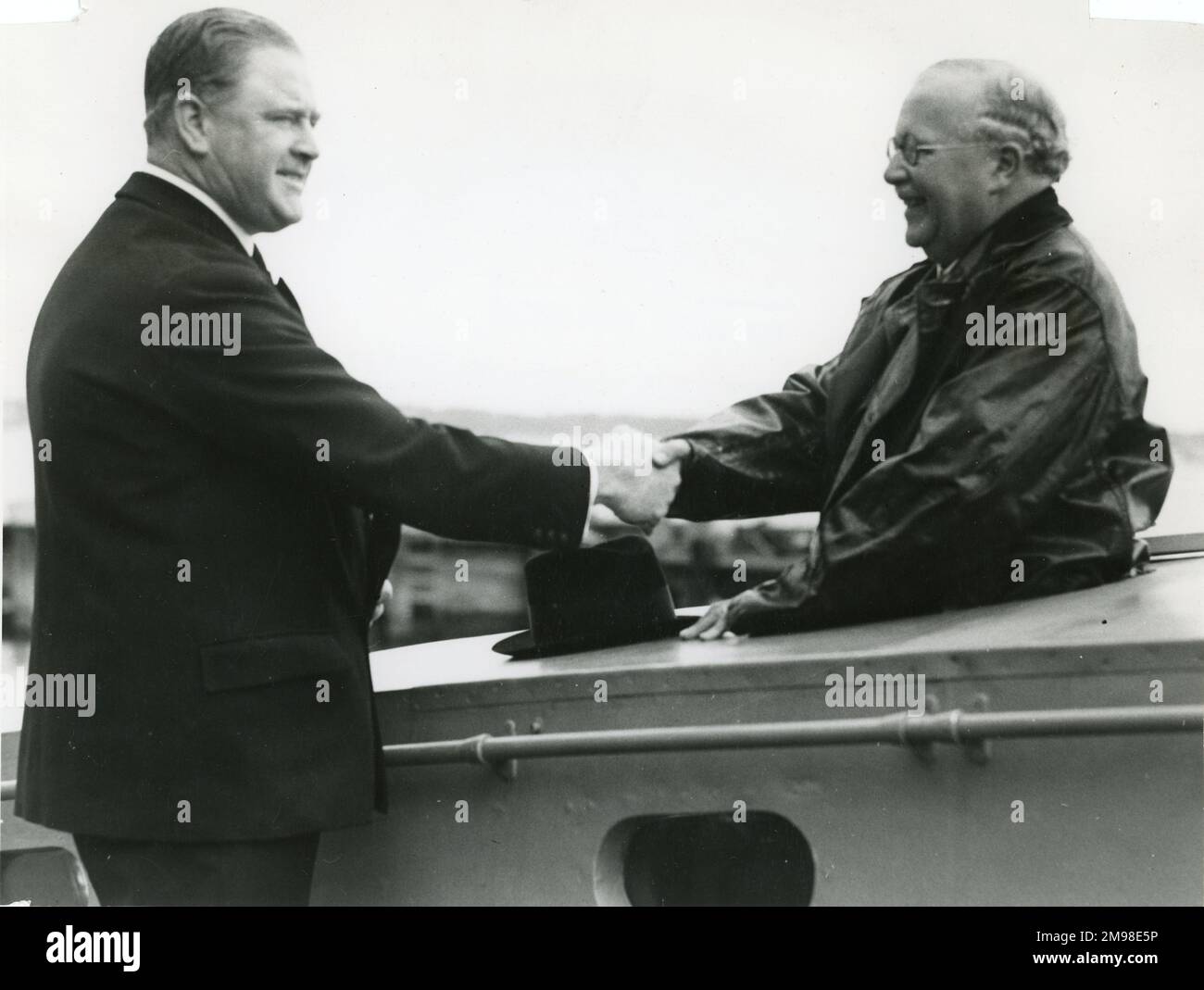 Sir Kingsley Wood is greeted by Mr Scott-Paine when inspecting an armoured target boat for the RAF, built by British Power Boat Co, Hythe, Southampton. Stock Photo