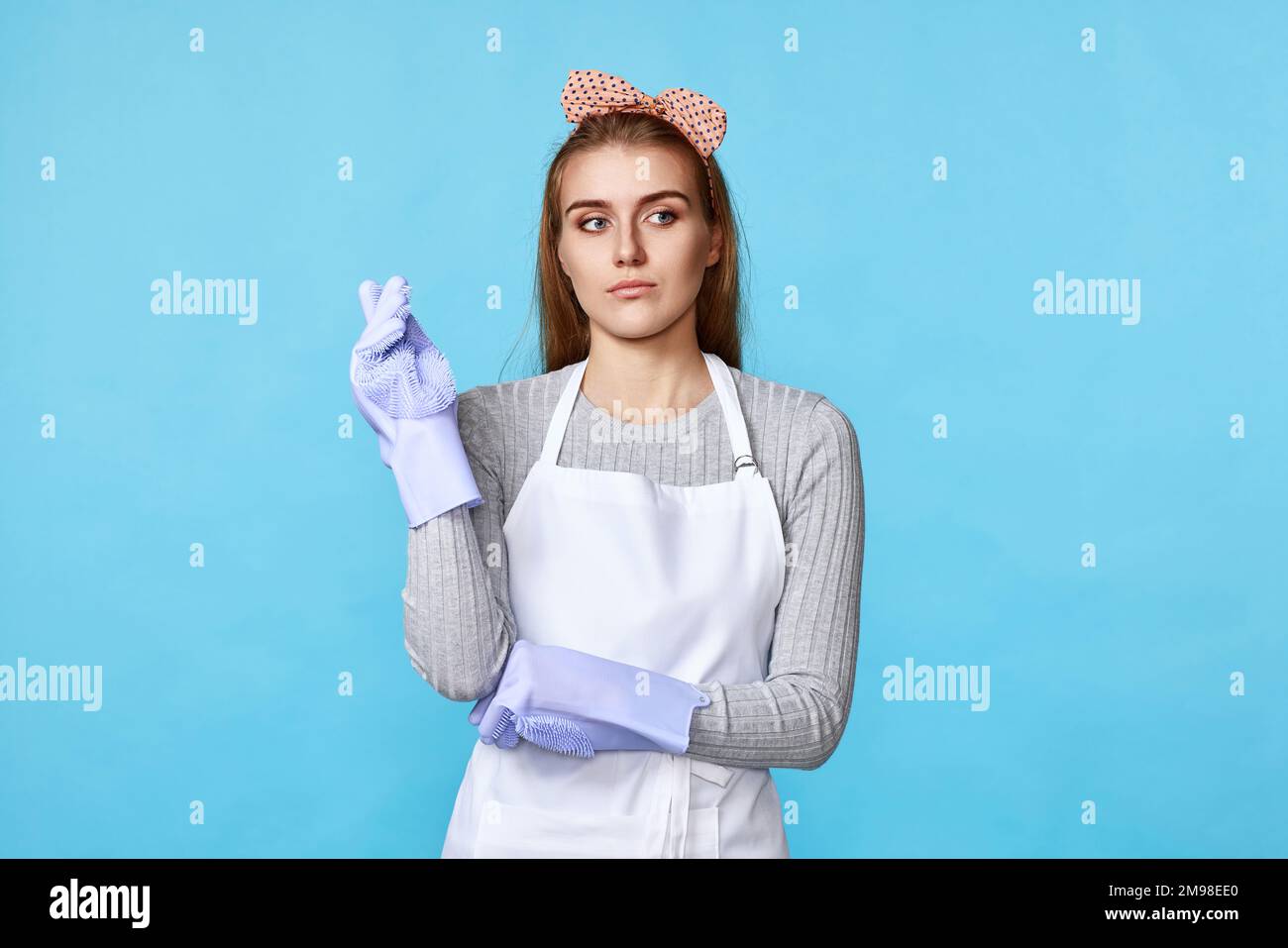 woman in rubber gloves and apron holding index finger up Stock Photo ...
