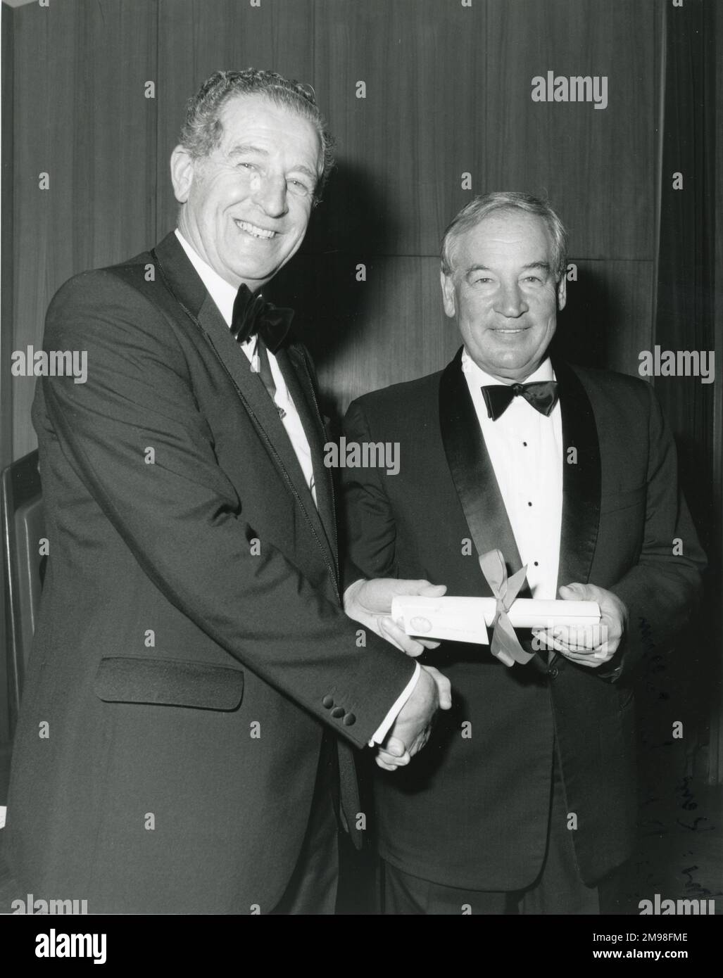 Joe Sutter, Executive Vice President of Operations and Product Development, Boeing, receives his Royal Aeronautical Society Honorary Fellowship from its President, Tom Kerr, in 1985. Stock Photo