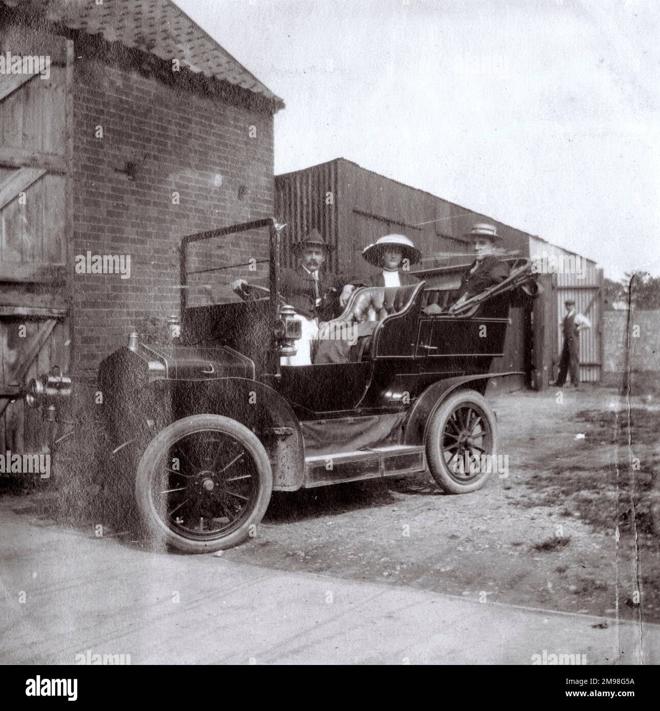 Three people in a car, ready to go for a spin in Southwold, Suffolk.  The owner and driver of the car is Henry John Sylvester Stannard RBA (1870-1951), artist. His passengers are Harold and Lucy Auerbach. Stannard gave painting lessons to the young Harold when the latter was in Southwold on holiday (1910-1912). Stock Photo