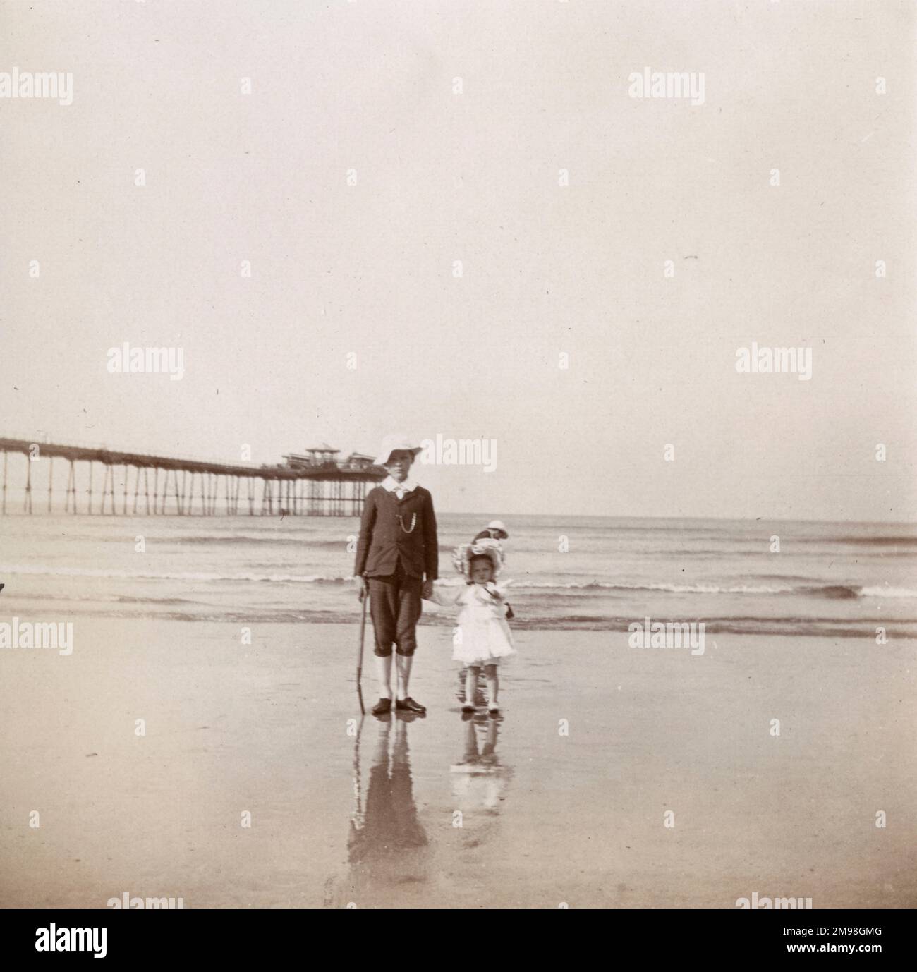 Boy (Albert Auerbach) and girl (Violet Auerbach) on the beach at Saltburn-by-the-Sea, North Yorkshire, August 1906.  The pier can be seen on the left. Stock Photo