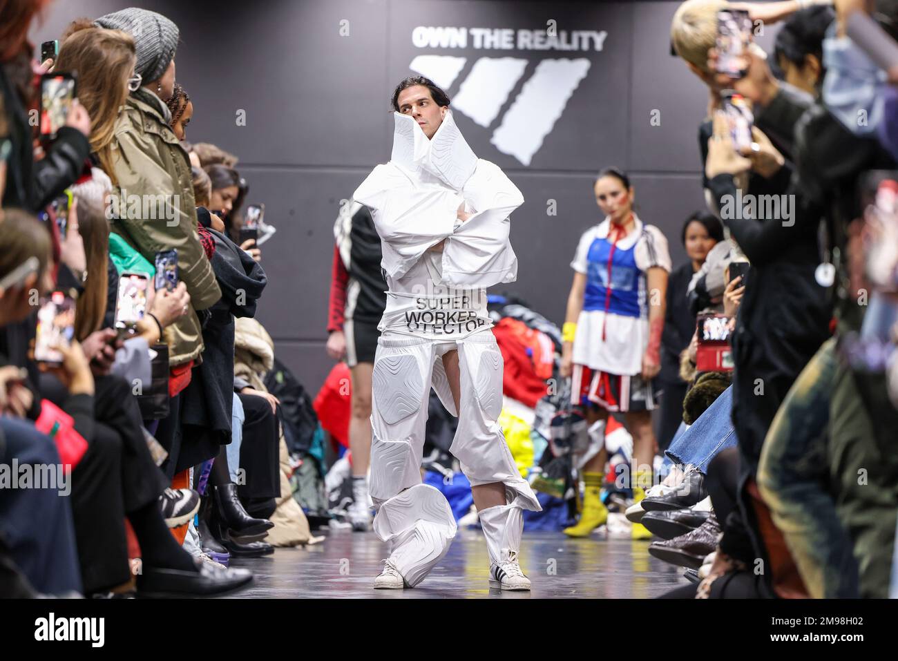 Berlin, Germany. 16th Jan, 2023. An activist walks the catwalk at a  performance disguised as an Adidas show during Berlin Fashion Week. For the  show, the New York-based action alliance The Yes