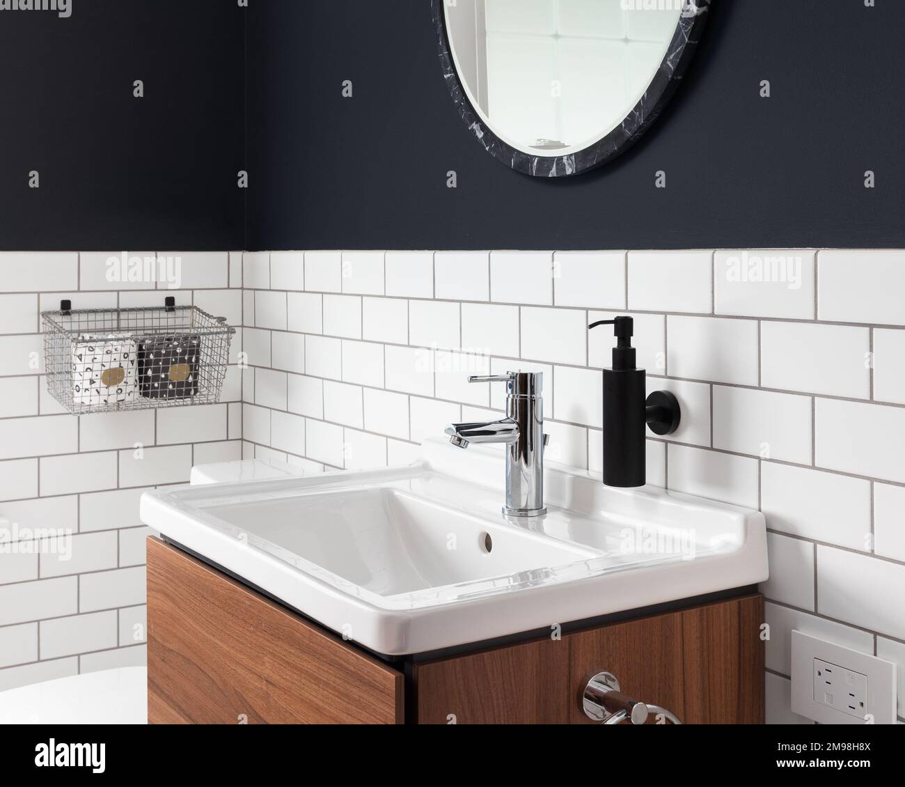 A Bathroom Sink Detail With Dark Blue Walls Subway Tiles A Circular   A Bathroom Sink Detail With Dark Blue Walls Subway Tiles A Circular Mirror And A Floating Wood Cabinet 2M98H8X 