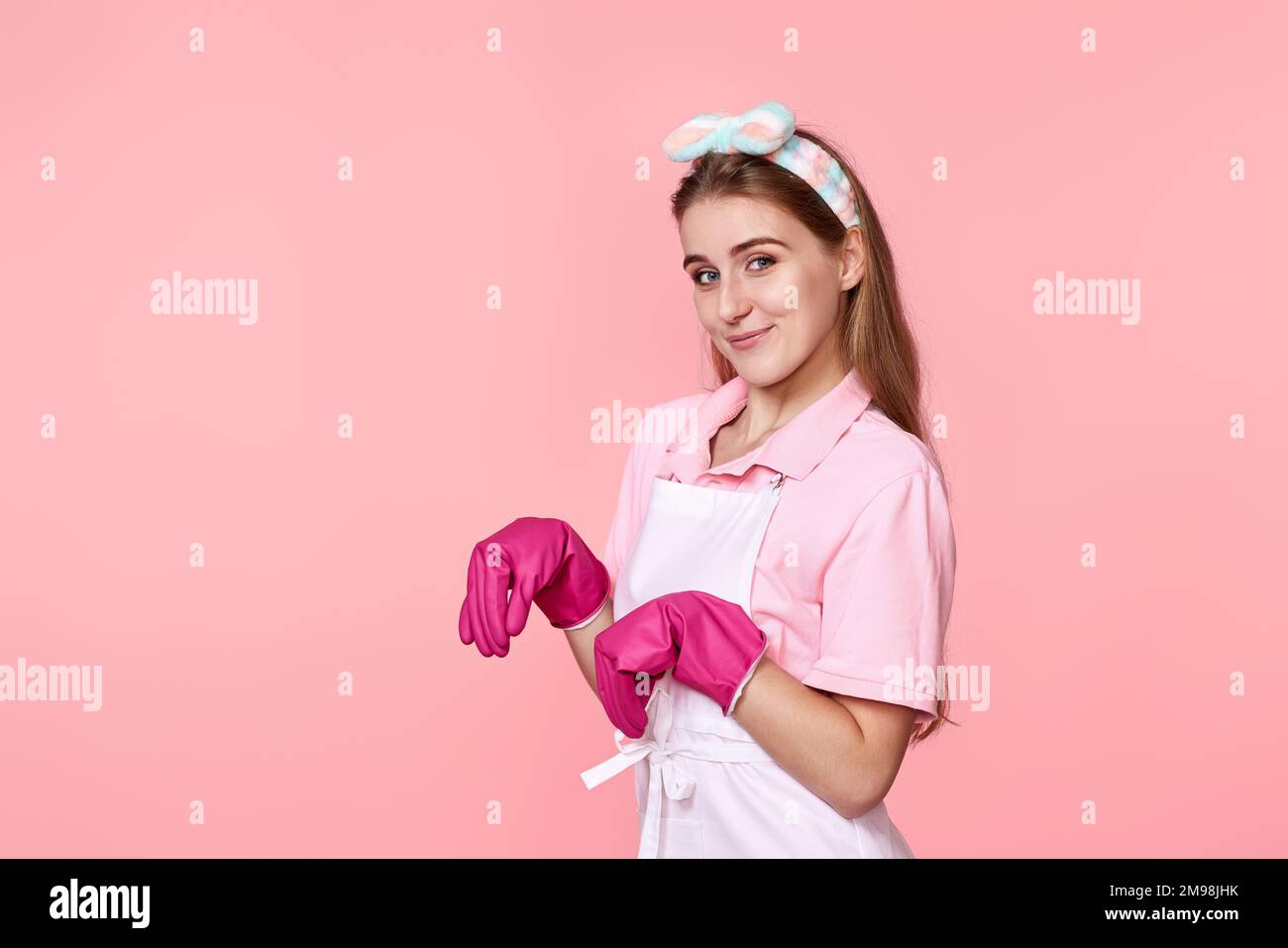 young woman in rubber gloves and cleaner apron Stock Photo