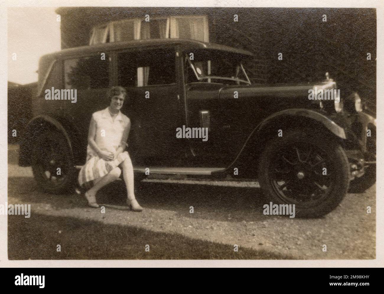 A lady ('Marion') sitting on the running board of her car Stock Photo