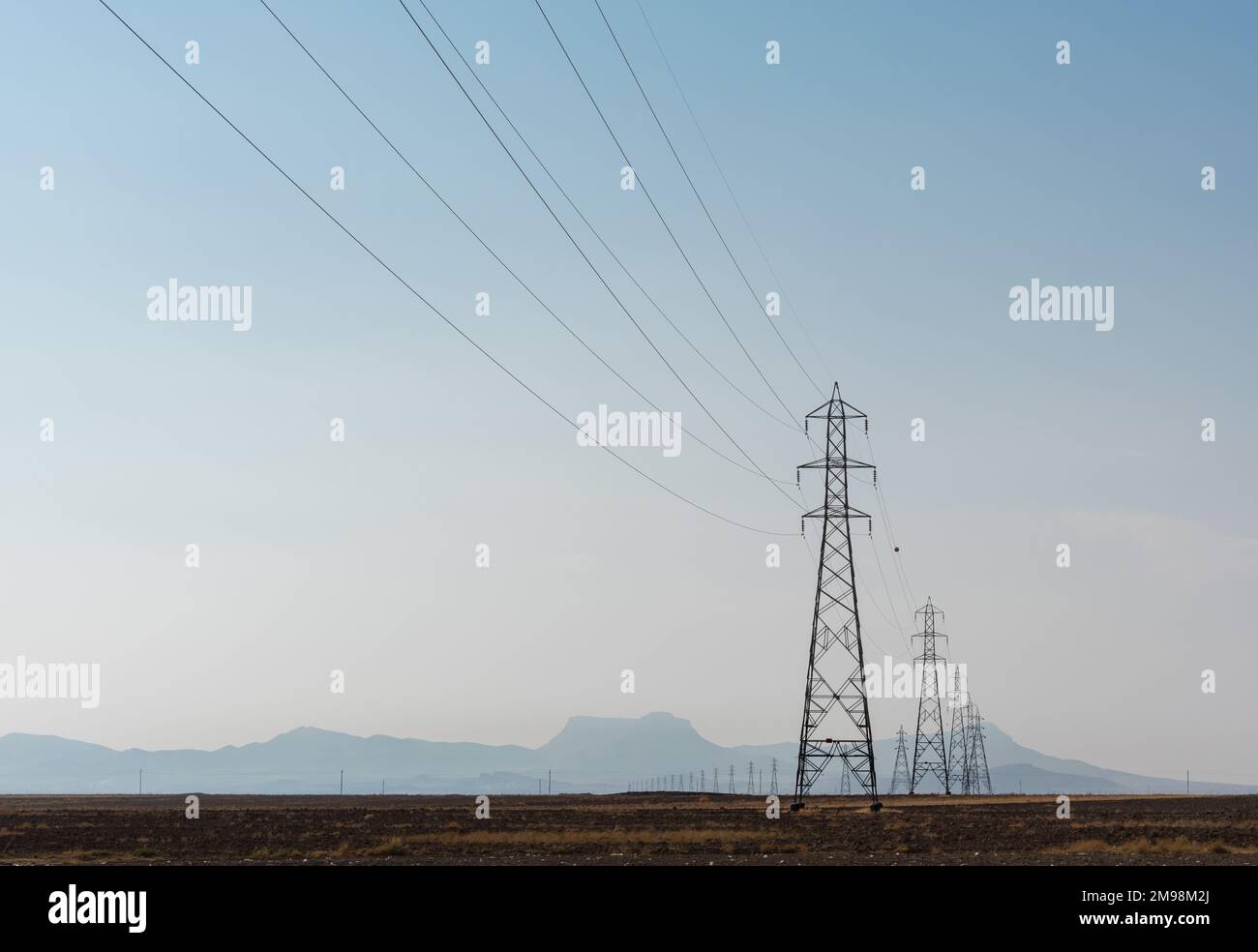 Electricity pylons in the desert Stock Photo