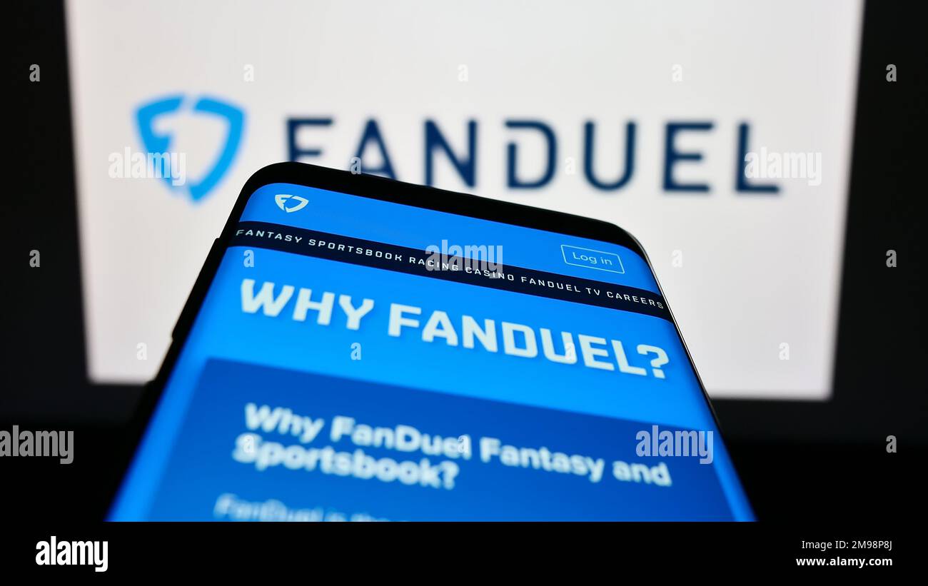 Mobile phone with website of US gambling company FanDuel Inc. on screen in front of business logo. Focus on top-left of phone display. Stock Photo