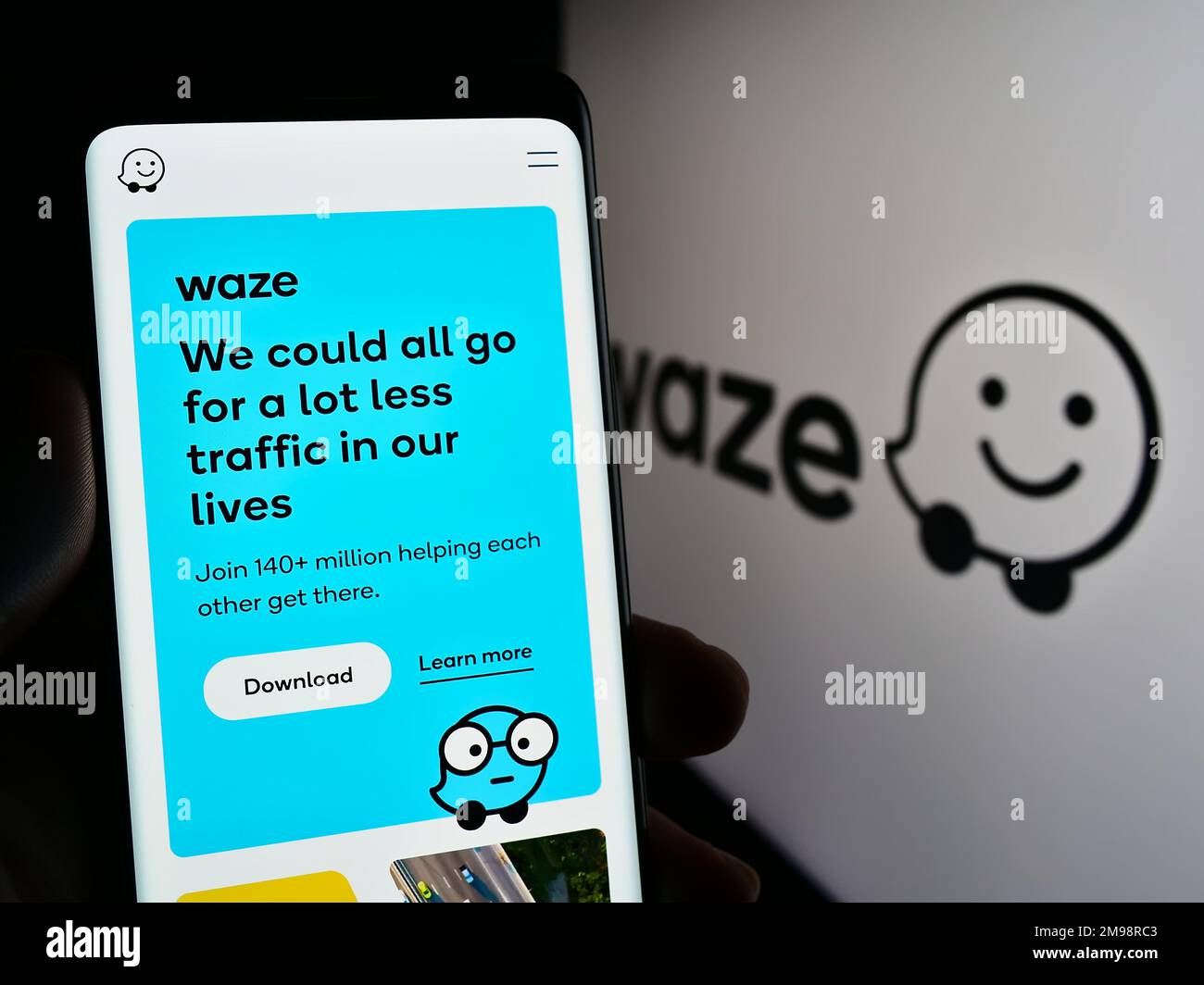 Person holding smartphone with website of Israeli navigation company Waze Mobile Ltd. on screen with logo. Focus on center of phone display. Stock Photo