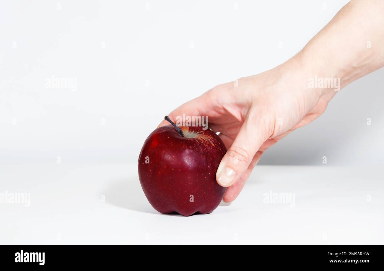Red ripe apple in woman's man's hand, on white background with hard ...
