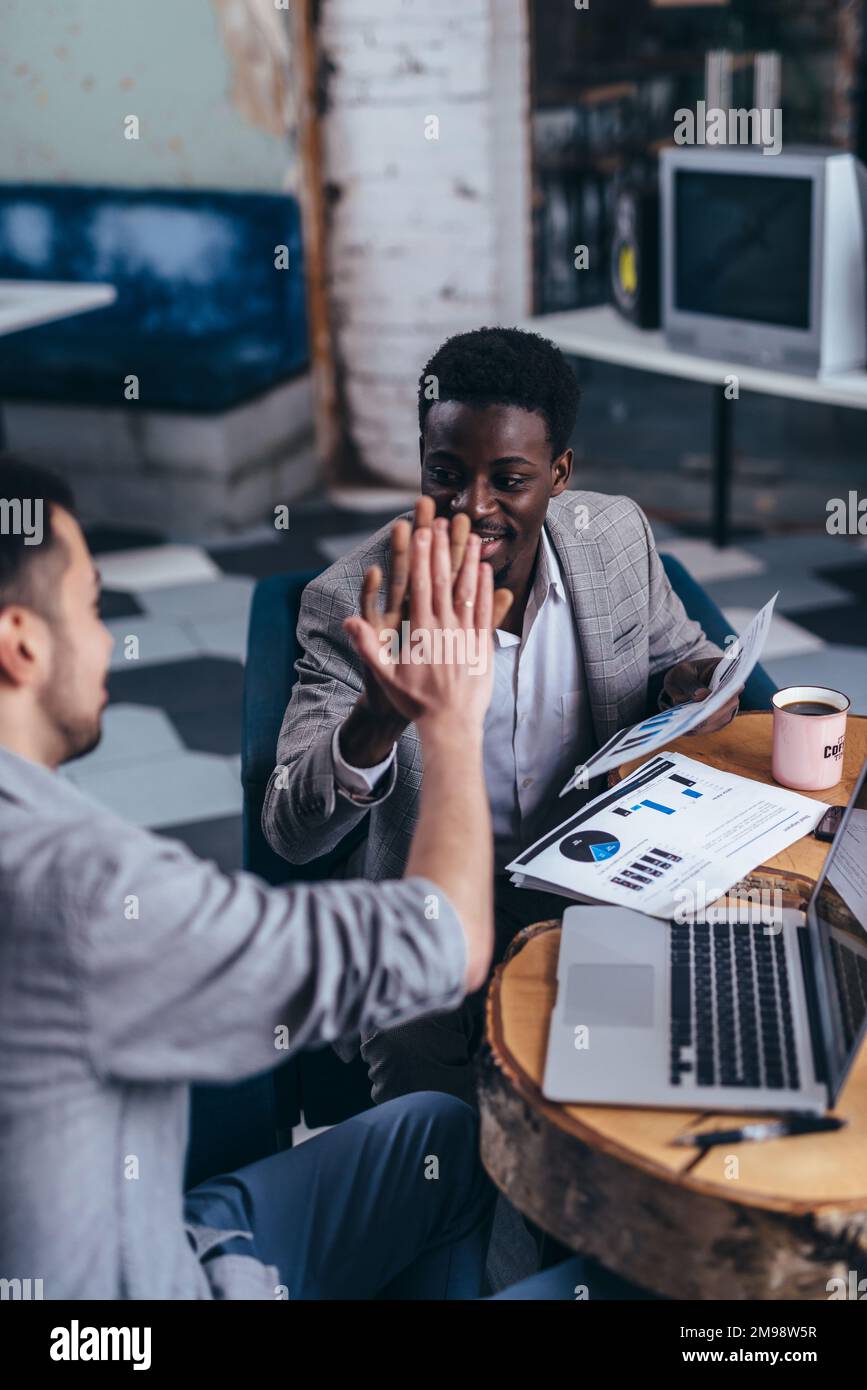 Business colleagues giving high five in office Stock Photo - Alamy