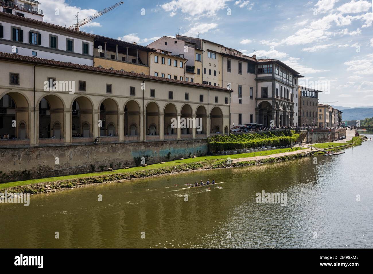 Florence, Italy - April, 15, 2022: Group rowing along the Arno River and past  The Uffizi Gallery Stock Photo