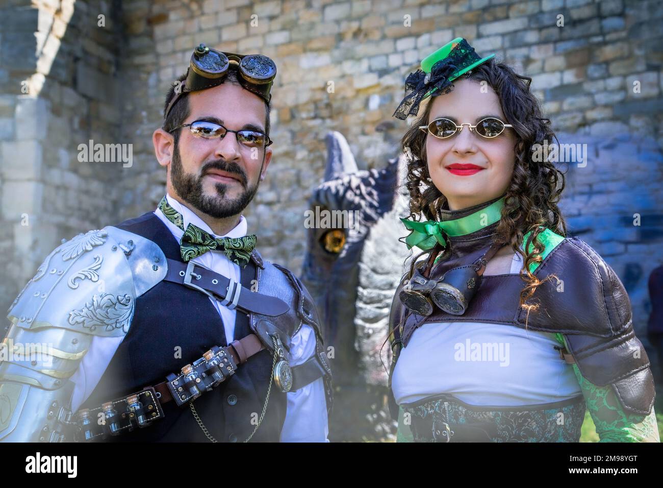 A male and female steampunk wearing retro futuristic clothing stand in