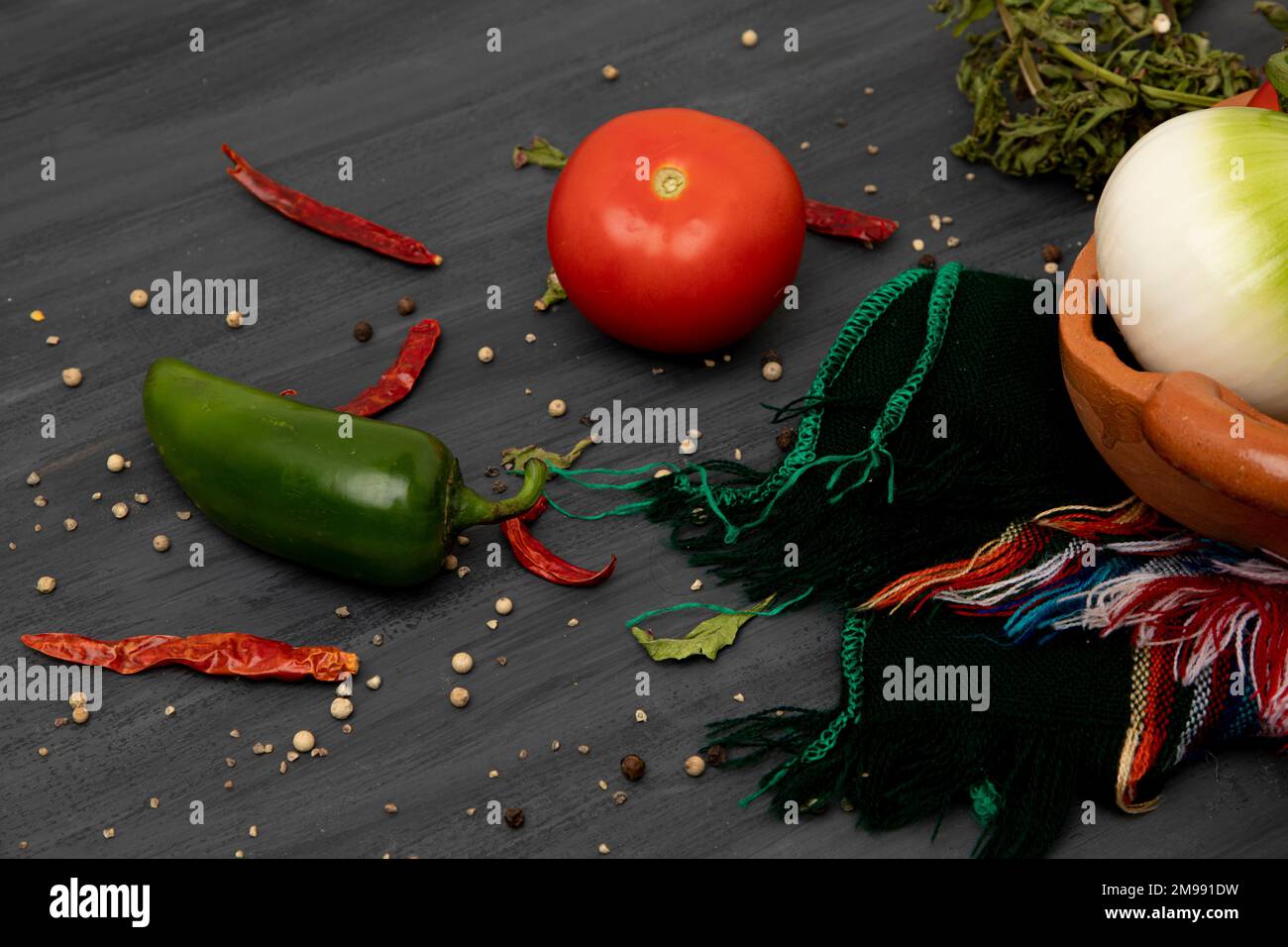Close up of ingredients to make salsa, focusing on a tomato and a chili Stock Photo