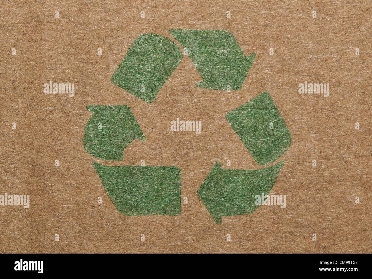 Green recycle symbol printed on a cardboard box, closeup isolated macro view. Stock Photo