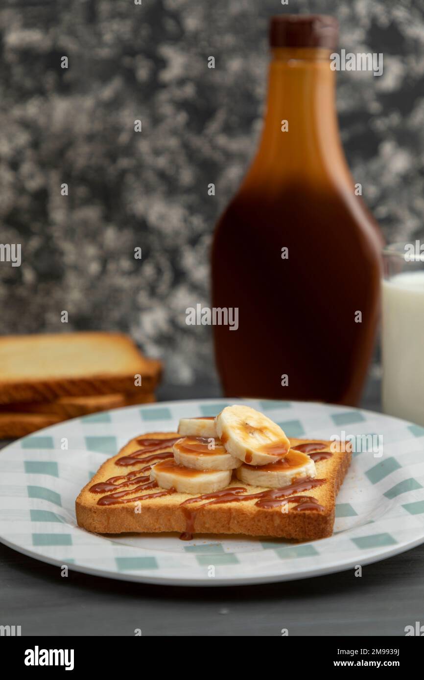toasted bread in the foreground with banana and cajeta. Stock Photo