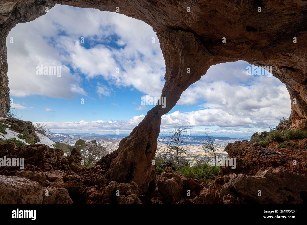 Bolumini cave from the inside, in the background a snowy landscape with blue sky. Mariola natural park ,Agres, Alicante, Spain. Stock Photo