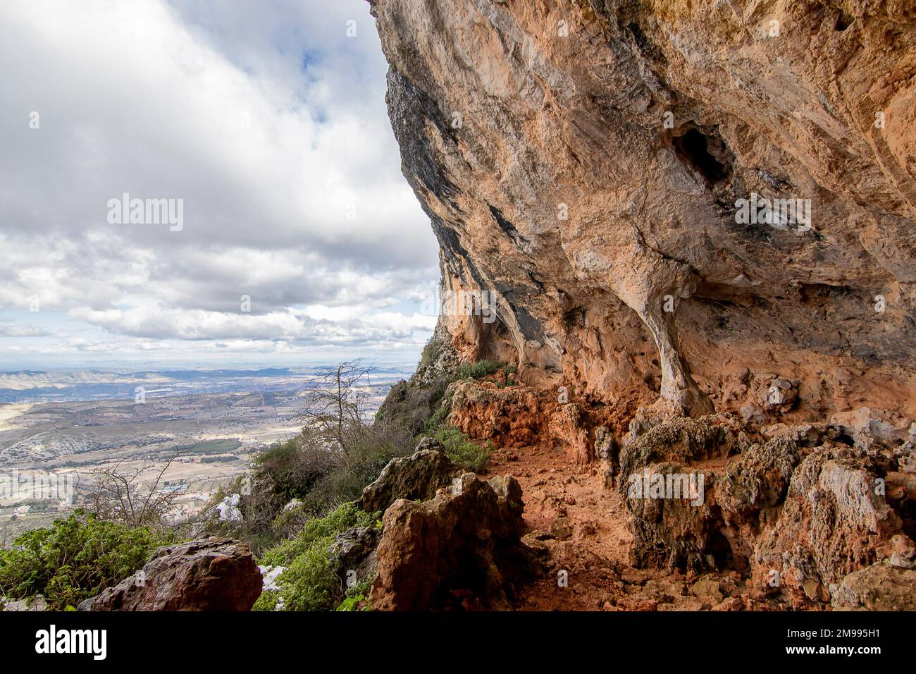Bolumini cave over snowy landscape with blue sky. Mariola Natural Park, Agres, Alicante, Spain. Stock Photo