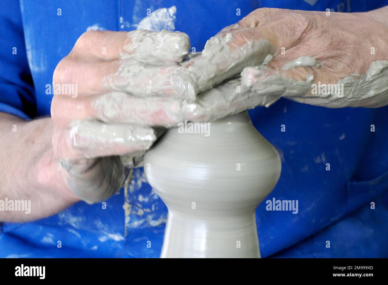 Craftsman painting and decorating ceramic products in pottery factory in Fez, Morocco, North