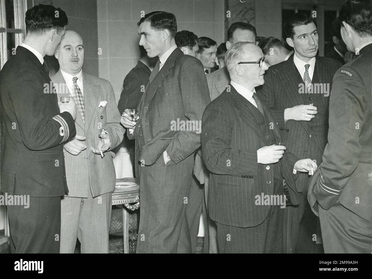 Students from No 6 Course Empire Test Pilots?s School toured the Avro factories on 15 and 16 December 1947 when they completed a series of visits to the aircraft manufacturers. Enjoying a cocktail before dinner are, from left: Lt Cdr G. Hawkes, RN; F.V. Smith, CBE, General Works Manager; Cdr F.M.A. Torrens-Spence, DSO, DSC, RN, OC Flying at the School; C.E. Fielding, OBE, Director; and J.A.R. Kay, Sales Manager. Stock Photo