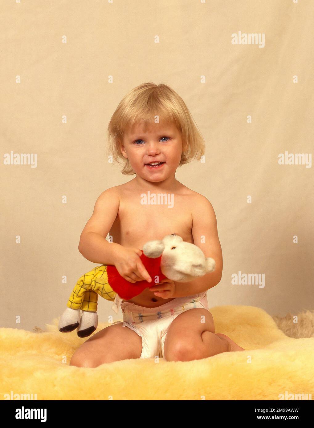 Toddler girl holding teddy bear in studio setting, Greater London, England, United Kingdom Stock Photo