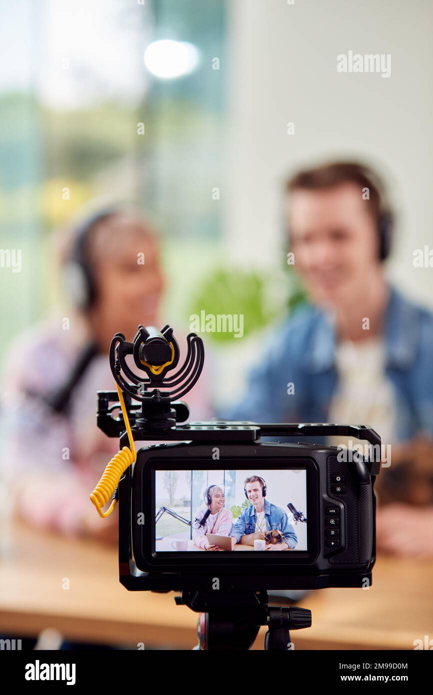Couple With Dog Recording Podcast Or Broadcasting Interview On Radio In Studio At Home With Laptop Stock Photo