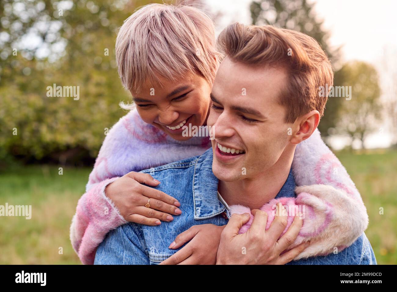 Loving Couple Outdoors In Countryside Laughing And Hugging Stock Photo