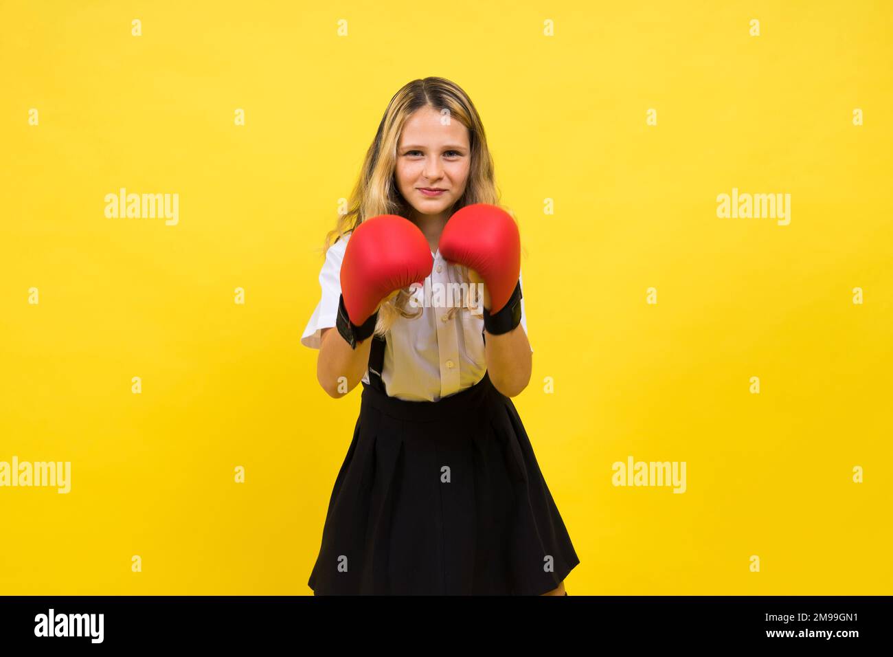 An adorable little girl boxer practicing punches in studio Stock Photo