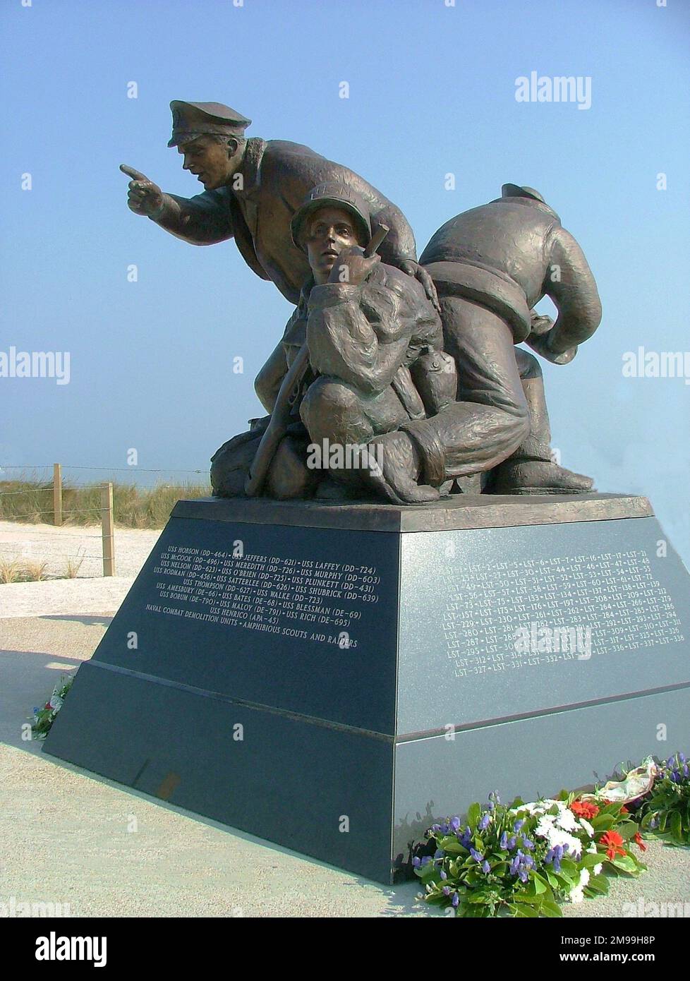 The three 8-feet tall bronze figures represent a Naval Captain, a sailor with a 5 inch shell and a member of a demolition team carrying a rifle. The sculptor was Stephen Spears and it was unveiled on 27 September 2008. Stock Photo