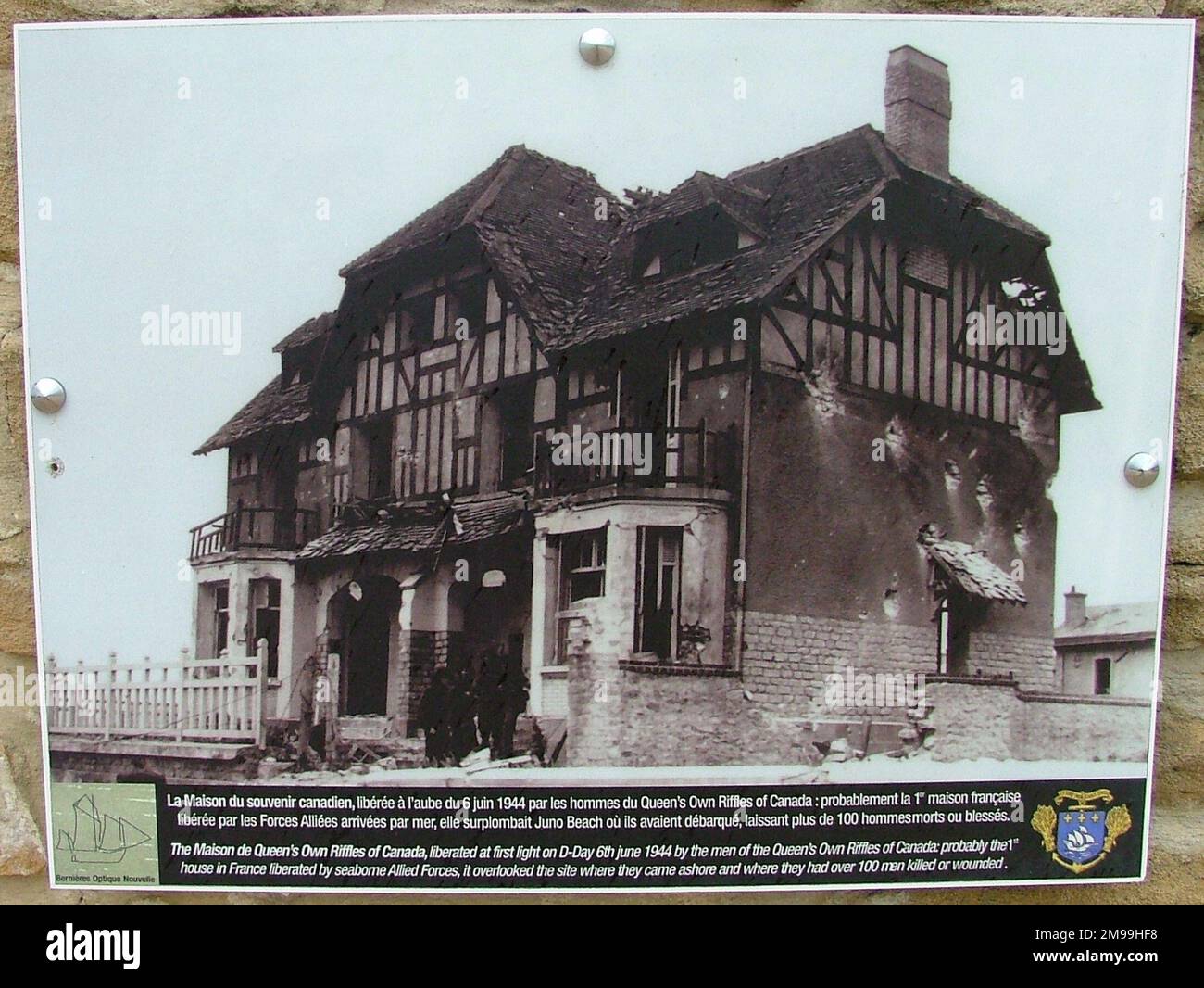 Despite the heavy bombardments from sea and air this building retained its form and shape as can be seen in this D Day picture displayed outside today. There are  several pictures of the landings which faced heavy opposition. Stock Photo