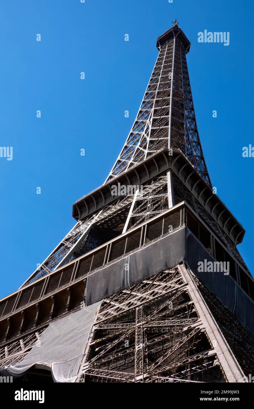 A view of the Eiffel Tower, Paris, France. The iconic tower is viewed from the base looking to the top of the tower against a blue sky Stock Photo