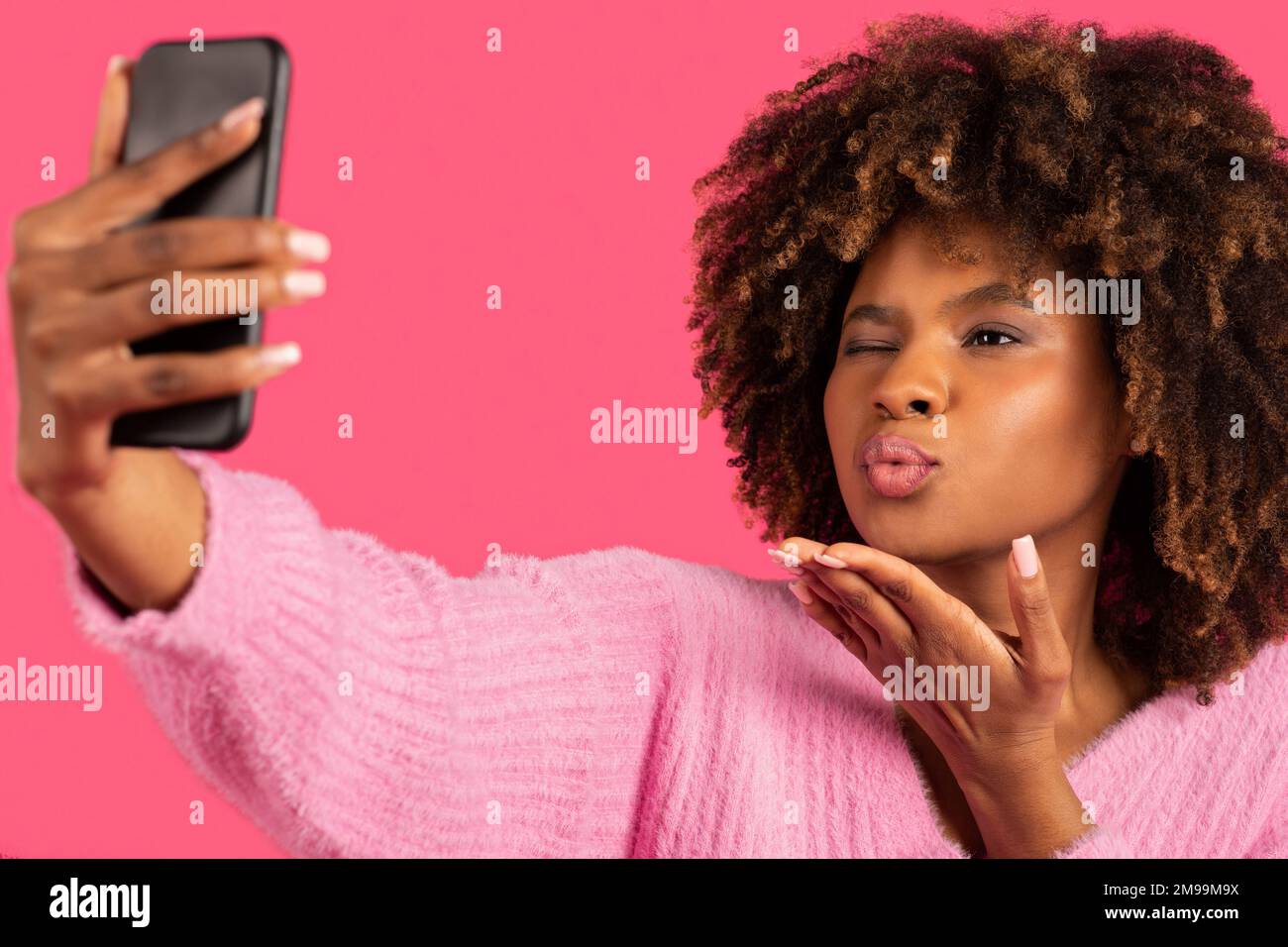 Happy young african american curly woman taking selfie on smartphone ...